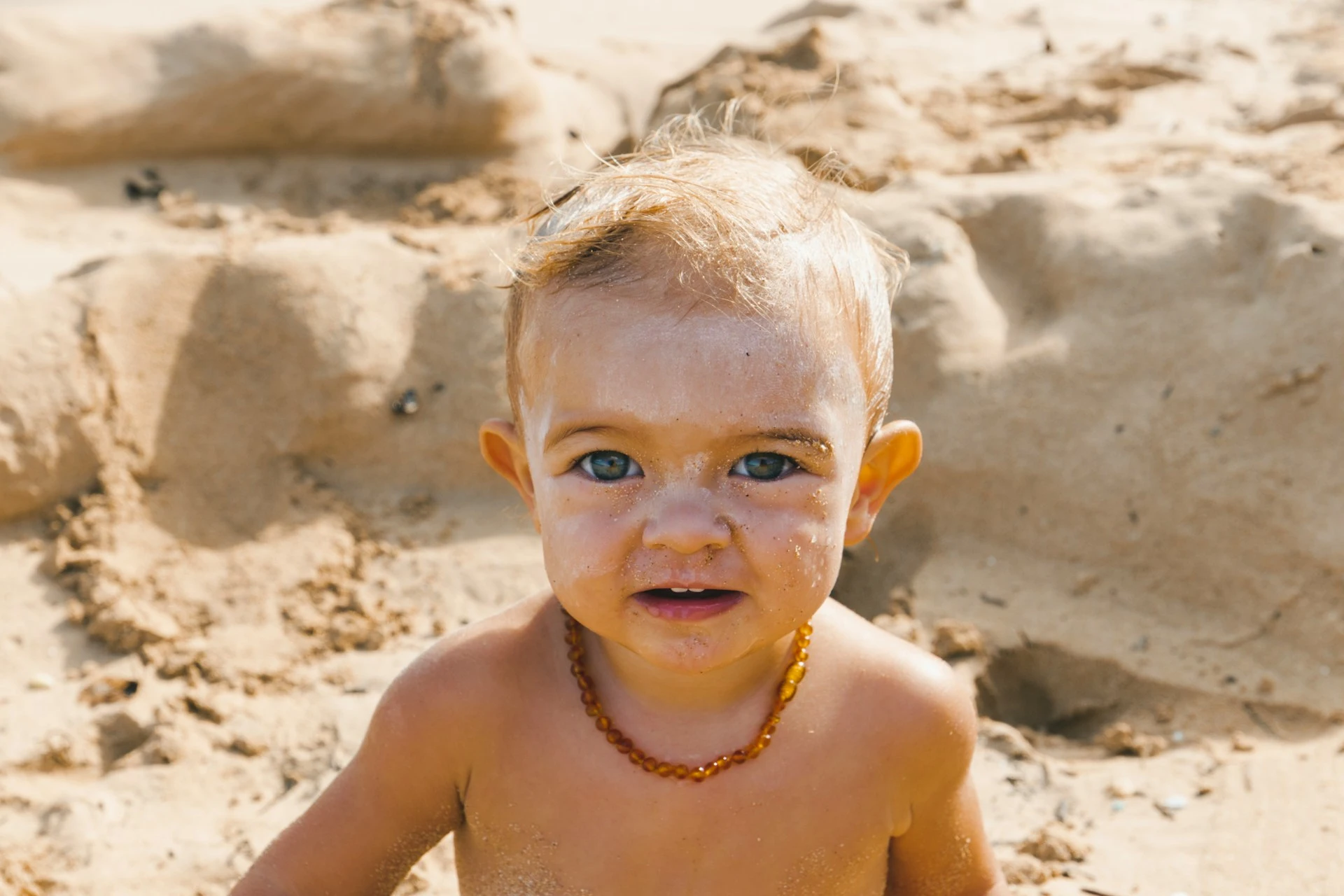 un bébé qui est tartiné de crème solaire